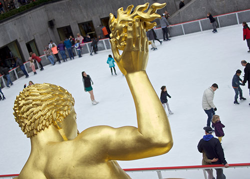 Back of the prometheus statue, at Rockefeller center in New York City, square with ice skaters in the background